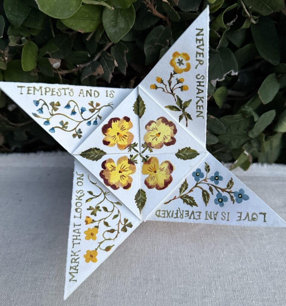 a folded, illustrated piece of paper covered in flower designs that functions like a narrative that can be unfolded to reveal the message
